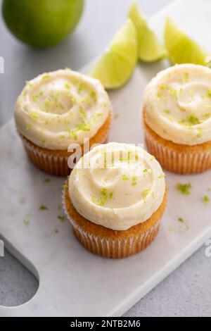 Kokosnuss- und Limetten-Cupcakes auf dem Servierbrett, Limettenkuchen-Dessert Stockfoto