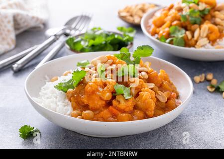 Blumenkohl-Curry mit Erdnüssen und Koriander auf Reis Stockfoto