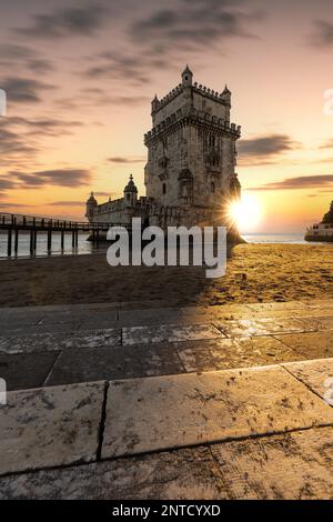 Der Torre de Belem, ein historischer Wachturm oder Verteidigungsturm, der auf einem Felsen am Ufer des Flusses Tejo gebaut wurde, Sonnenuntergang im Stadtteil Belem Stockfoto