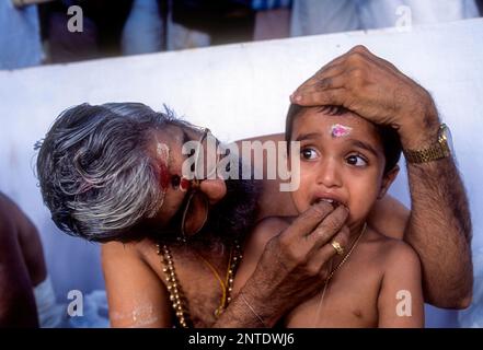 Ezhuthiniruthu-Zeremonie am Vijayadasami-Tag im Saraswathy-Tempel in Panachikadu in der Nähe von Kottayam, Kerala, Indien. Der Priester schrieb ein paar Alphabete drauf Stockfoto