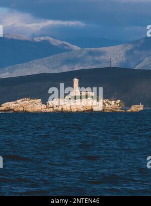 Blick auf den Leuchtturm von Peristeres Kaparelli auf einer Insel im Ionischen Meer, Griechenland, vom Dorf Kassiopi, der Insel Korfu, mit Albanien la Stockfoto
