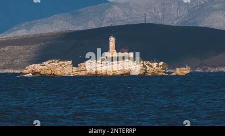 Blick auf den Leuchtturm von Peristeres Kaparelli auf einer Insel im Ionischen Meer, Griechenland, vom Dorf Kassiopi, der Insel Korfu, mit Albanien la Stockfoto