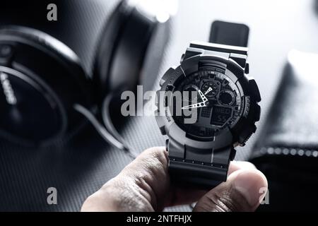 Nahaufnahme einer schwarzen analog-digitalen Hybrid-Sportarmbanduhr. Lässiges Accessoire für Herren. Stockfoto