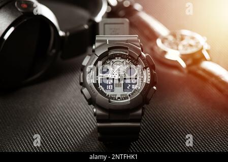 Nahaufnahme einer schwarzen analog-digitalen Hybrid-Sportarmbanduhr. Lässiges Accessoire für Herren. Stockfoto