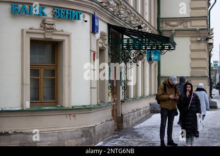 Moskau, Russland. 27. Februar 2023. Die Leute gehen an der Zenit Bank in Moskau vorbei. Das Vereinigte Königreich setzte die Bank auf die schwarze Liste, die die Konten und Vermögenswerte der bankís im Vereinigten Königreich sperrte und es ihren Bürgern und Unternehmen untersagte, Transaktionen mit der Bank zu tätigen. Kredit: SOPA Images Limited/Alamy Live News Stockfoto