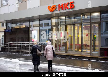 Moskau, Russland. 27. Februar 2023. Frauen gehen an einem Büro der Kreditbank von Moskau vorbei. Am 24. Februar, die USA Das Finanzministerium aktualisierte seine Liste der sanktionierten russischen Banken. Unter anderem zielten die Sanktionen auf die Moskauer Kreditbank ab, die zu den systemrelevanten Kreditinstituten in Russland gehört. Kredit: SOPA Images Limited/Alamy Live News Stockfoto