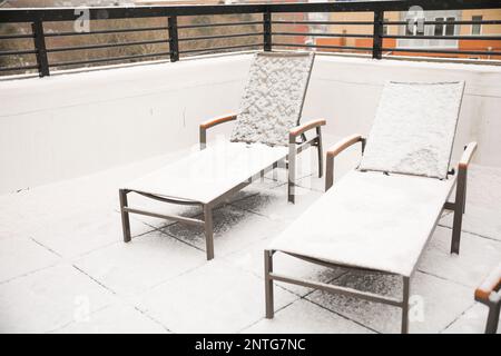 Schnee auf Bänken, Tischen und Stühlen im Freien im Winter, bedeckt von weißem Schneefall während des Sturms in der Stadt Providence Stockfoto