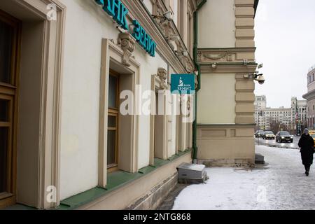 Moskau, Russland. 27. Februar 2023. Eine Frau geht am Büro der Zenit Bank in Moskau vorbei. Das Vereinigte Königreich setzte die Bank auf die schwarze Liste, die die Konten und Vermögenswerte der bankís im Vereinigten Königreich sperrte und es ihren Bürgern und Unternehmen untersagte, Transaktionen mit der Bank zu tätigen. (Foto: Vlad Karkov/SOPA Images/Sipa USA) Guthaben: SIPA USA/Alamy Live News Stockfoto