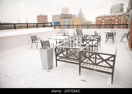 Schnee auf Bänken, Tischen und Stühlen im Freien im Winter, bedeckt von weißem Schneefall während des Sturms in der Stadt Providence Stockfoto