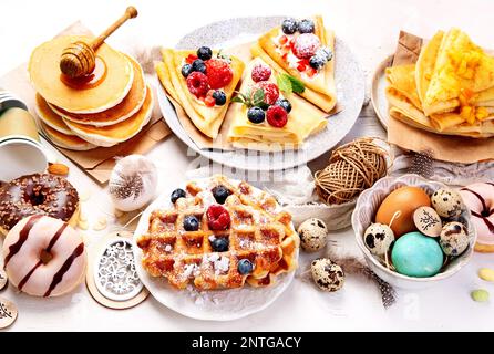 Umweltfreundlicher Osterdesserttisch im Frühling. Zero Waste Osterkonzept traditionelle, natürliche, farbenfrohe Eier. Stockfoto