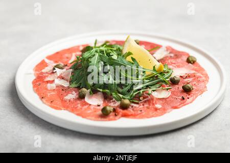 Carpaccio mit Kapern, Rucola und Parmesan Stockfoto