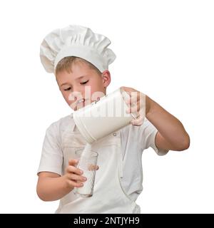 Ein Junge in weißer Koch-Kleidung kocht in einer Küche zu Hause, isoliert auf weißem Hintergrund Stockfoto