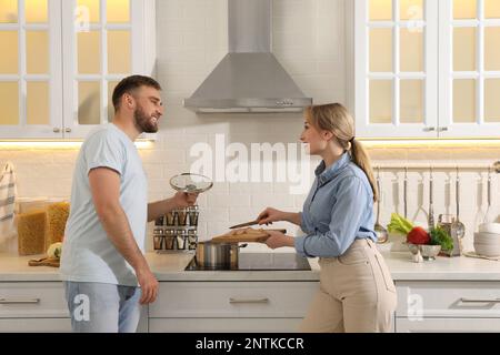 Ein junges Paar, das in der Küche köstliches Bouillon zubereitet. Hausgemachtes Rezept Stockfoto