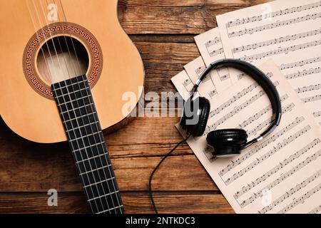 Komposition mit Gitarre und Noten auf Holztisch, flach liegend Stockfoto