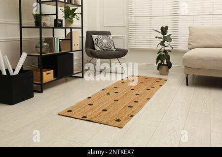 Stilvolle Einrichtung mit modernen Möbeln und Korbläufer-Teppich Stockfoto