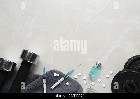 Verschiedene Drogen und Sportgeräte auf grauem Hintergrund, flach liegend mit Platz für Text. Dopingkontrolle Stockfoto