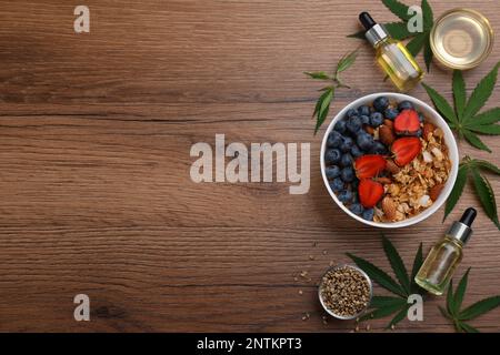 CBD-Öl, THC-Tinktur, Hafermehlschale, Hanfblätter und Samen auf Holztisch, flach liegend. Platz für Text Stockfoto