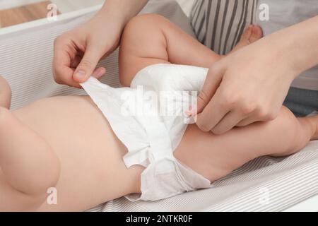 Mutter, die die Windel des Babys wechselt, auf dem Tisch, Nahaufnahme Stockfoto