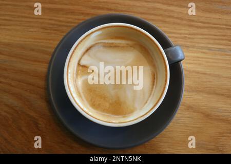 Kaffeetassen, die in einem Café auf einen Tisch gestellt werden, leeren Sie die Kaffeetasse, nachdem der Kaffee verschwunden ist. Stockfoto