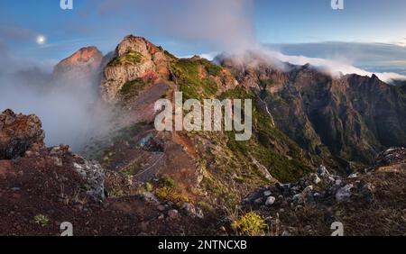 Berglandschaft bei Sonnenuntergang auf Madeira. Atemberaubender Blick auf bunte Wolken und schattige Berge. Stockfoto