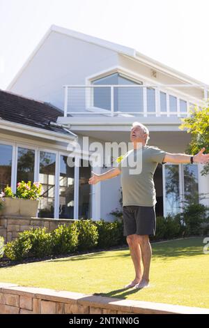 Ein glücklicher Chefkaukasier, der Yoga macht und sich im Garten streckt Stockfoto