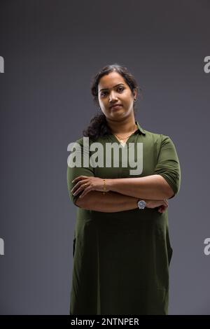 Porträt einer Indianerin, stehende Pose mit verschiedenen Gesten, mit grauem Hintergrund, isoliert. Stockfoto