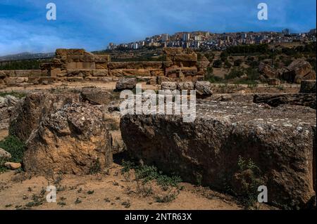 Antik und modern: Apartmentblöcke in der Stadt Agrigento in Süd-Sizilien, Italien, mit Blick auf das Tal der Tempel, die Stätte des antiken Graeco-römischen Akragas oder Agrigentum und die verstreuten und verwitterten Überreste des riesigen Tempels des Olympischen Zeus oder Jupiter; Erbaut um 480 v. Chr. und eines der größten dorischen Bauwerke der griechischen Antike. Stockfoto