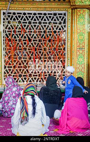 junge und Gebete in Hazrat Nizamuddin Dargah, Delhi, Indien Stockfoto