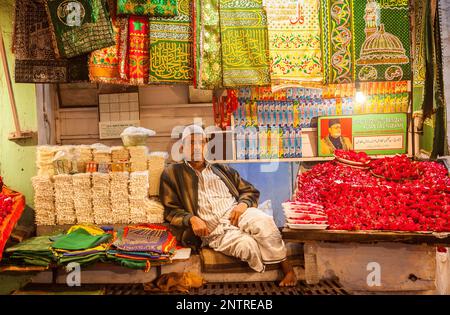 Verkäufer von religiöse Angebote, Souvenirs und Schrank für Schuhe, Eintritt ins Hazrat Nizamuddin Dargah, Delhi, Indien Stockfoto