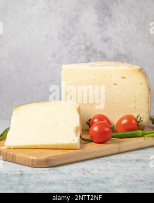 Radkäse. Käse aus Kuhmilch auf einem hölzernen Flipchart. Türkischer Greyerekäse Stockfoto