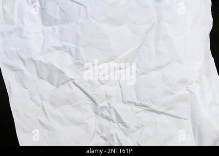 Zerknittertes Papier Draufsicht Nahaufnahme eines zerknitterten Blatts weißes Papier. Draufsicht strukturierter Papierhintergrund, dunkle Betonstruktur. Platz für Text Stockfoto