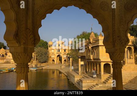 Gadi Sagar, der Tank war einst der Wasserversorgung der Stadt und ist umgeben von kleinen Tempeln und Schreinen, im Hintergrund rechts Thilon Ki Pol Bogen Stockfoto