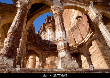 Palasttürme des Meherangarh Fort durch die Überreste eines steinernen Tempels gesehen, Jodhpur, Rajasthan, Indien Stockfoto