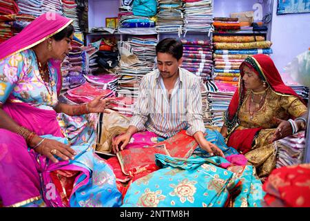 Lieferant und Kunde in der Kleidung zu speichern, Sardar Markt, Jodhpur, Rajasthan, Indien Stockfoto