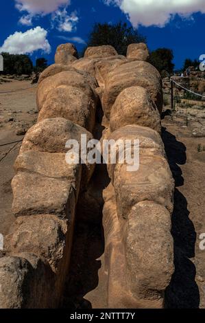 Kolossale Liegestatue des Atlas, eine 8 m lange Nachbildung einer von 38 telamon-Säulen, die die Einbuchtung des riesigen Tempels des Olympischen Zeus im Tal der Tempel stützte, dem Ort der Stadt Akragas in Agrigento, Sizilien, Italien. Stockfoto