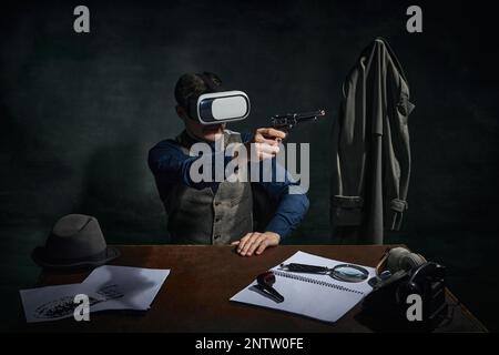 Professioneller Detektiv in klassischer Kleidung, trägt eine VR-Brille vor dunkelgrünem Vintage-Hintergrund. Untersuchung. Moderne Technologien Stockfoto