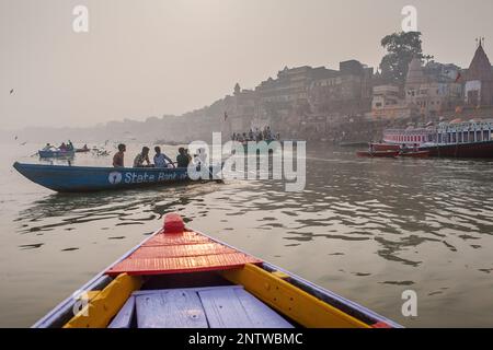 Pilger in einem Boote Segeln und beten, Fluss Ganges, im Hintergrund die Ghats, Varanasi, Uttar Pradesh, Indien. Stockfoto