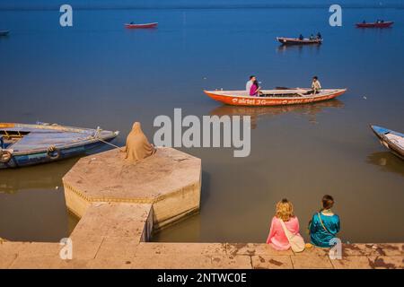 Man betet und Touristen, die in Lalita Ghat, Fluss Ganges, Varanasi, Uttar Pradesh, Indien. Stockfoto