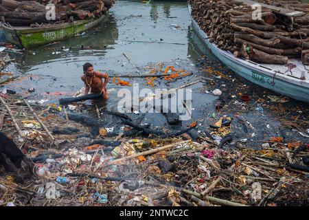 Wer gewinnt Holz für die Einäscherung, die nicht vollständig in Manikarnika Ghat, die brennenden Ghat, an den Ufern des Ganges Fluß, Vara gebrannt hat Stockfoto