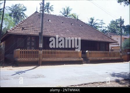 Kerala-Häuser:- die markanteste visuelle Form der Kerala-Architektur ist das lange, steil abfallende Dach, das zum Schutz der Wände des Hauses gebaut wurde und dem schweren Monsun widersteht, normalerweise mit Fliesen oder strohgedeckten Palmenlabyrinth, gestützt auf einem Dachrahmen aus Hartholz und Holz. Kerala ist ein Bundesstaat, der mindestens 6 Monate im Jahr Niederschläge erleidet, und bei einem solchen Klima sind geneigte Dächer immer besser. Kerala-Architektur folgt Thatchu Shasthra, einer Wissenschaft der Tischlerei, die die Gebäude-/Baunuancen regelt. Stockfoto