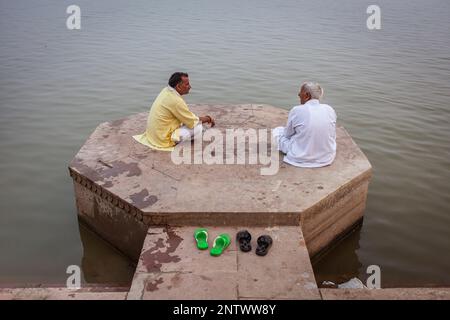 Männer, entspannen Sie sich mal in Lalita Ghat, Fluss Ganges, Varanasi, Uttar Pradesh, Indien. Stockfoto