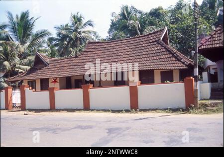 Kerala-Häuser:- die markanteste visuelle Form der Kerala-Architektur ist das lange, steil abfallende Dach, das zum Schutz der Wände des Hauses gebaut wurde und dem schweren Monsun widersteht, normalerweise mit Fliesen oder strohgedeckten Palmenlabyrinth, gestützt auf einem Dachrahmen aus Hartholz und Holz. Kerala ist ein Bundesstaat, der mindestens 6 Monate im Jahr Niederschläge erleidet, und bei einem solchen Klima sind geneigte Dächer immer besser. Kerala-Architektur folgt Thatchu Shasthra, einer Wissenschaft der Tischlerei, die die Gebäude-/Baunuancen regelt. Stockfoto