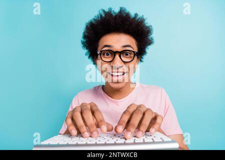Nahaufnahme eines jungen Witzbolds mit T-Shirt-Brille Schreiben Sie Text-Tastatur chatten Internet-Boten isoliert auf aquamarinfarbenem Hintergrund Stockfoto