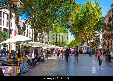 Verkaufsstände und Menschen, die entlang der Rambla, Barcelona, Katalonien, Spanien spazieren gehen Stockfoto