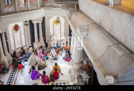 Gruppe von Menschen, die beten, in ISKCON Tempel Sri Krishna Balaram Mandir, Vrindavan, Mathura, Uttar Pradesh, Indien Stockfoto