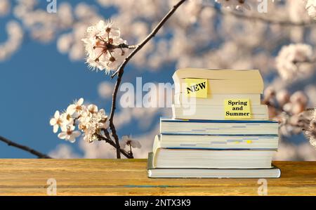 Neue Buchveröffentlichungen für Frühjahr 2023, mit einem Stapel Bücher und Kirschblüten Hintergrund. Frühjahrsbuchmesse, Inspiration, Lesen, Bildung, Literaturbetrug Stockfoto