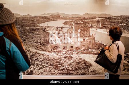 Besucher sieht ein Foto von Hiroshima nach der Atombombe Explosion, Hiroshima Peace Memorial Museum, Hiroshima, Japan Stockfoto