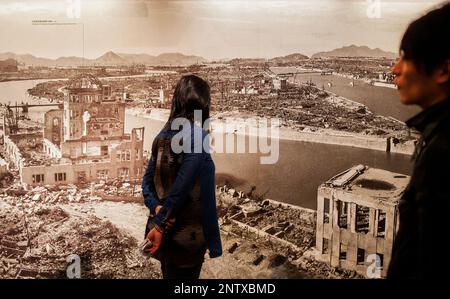 Besucher sieht ein Foto von Hiroshima nach der Atombombe Explosion, Hiroshima Peace Memorial Museum, Hiroshima, Japan Stockfoto