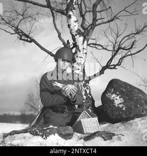 Schwedische Armee im Jahre WW2. Man sieht einen Soldaten, der eine Taube in der Hand hält. Kriegstauben wurden während des Zweiten Weltkriegs vom schwedischen Militär benutzt Die Tauben trugen Nachrichten von einem Ort zum anderen, oft ein Stück Papier in einem kleinen Metallbehälter, der an seinem Bein befestigt war. Brieftauben wurden von einer Spezialeinheit des schwedischen Militärs behandelt und ausgebildet. Brieftauben spielten eine wichtige Rolle bei der Invasion der Normandie, da Funkgeräte nicht aus Angst benutzt werden konnten, dass wichtige Informationen vom Feind abgefangen werden. Schweden dezember 1940. Kristoffersson Ref. 184-3 Stockfoto