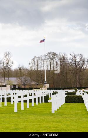 Grabsteinkreuze und amerikanische Flagge am Cambridge American Cemetery and Memorial, Madingley, Cambridgeshire, England Stockfoto